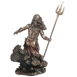 Bronze-hued statue of Greek ocean god Poseidon holding trident, standing on waves, shown from the back