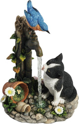 Figurine of cat drinking from garden faucet with bluebird perched on spigot