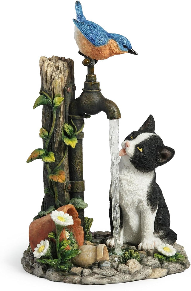 Figurine of cat drinking from garden faucet with bluebird perched on spigot