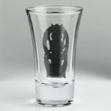 A clear glass shot glass featuring a detailed pewter relief of a triple moon goddess figure, Hecate, flanked by two wolves. Shown from the back