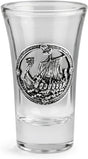 A clear glass shot glass featuring a pewter Viking ship medallion on the front