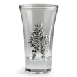 A clear glass shot glass featuring an embossed pewter Viking warrior holding a shield and sword