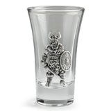 A clear glass shot glass featuring an embossed pewter Viking warrior holding a shield and sword
