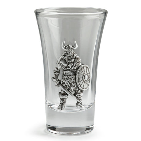 A clear glass shot glass featuring an embossed pewter Viking warrior holding a shield and sword