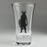 A clear glass shot glass featuring an embossed pewter Viking warrior holding a shield and sword, shown from the back