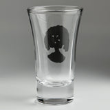 A clear glass shot glass featuring a detailed pewter tree of life emblem, shown from the back
