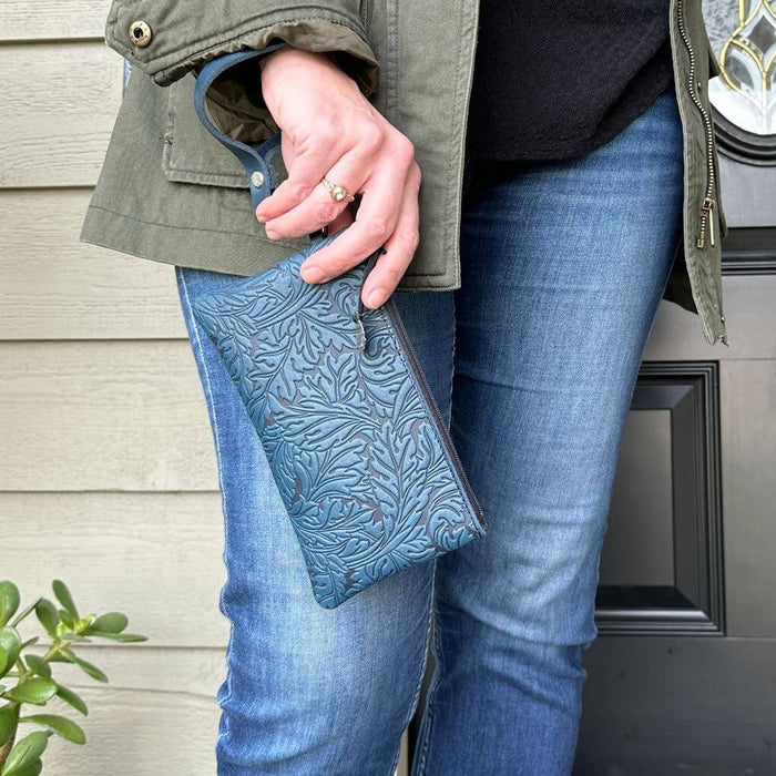 Navy acanthus leather wristlet paired with blue jeans
