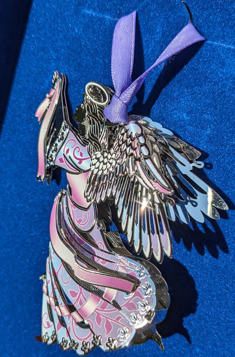 Metal ornament of an angel wearing a swirl patterned dress of pink and blue