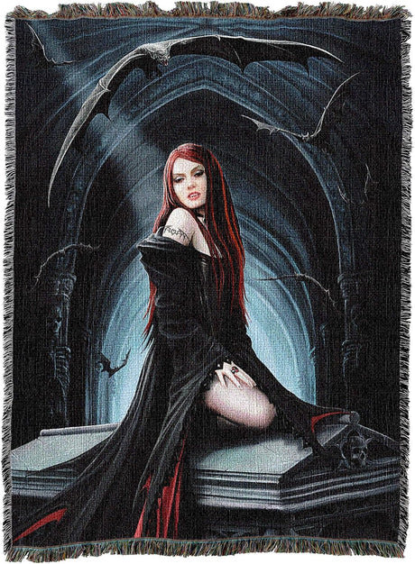 A woven throw blanket featuring a dark gothic fantasy illustration of a red-haired vampire woman in a black dress seated on a coffin, with bats and a blue-lit archway in the background. The blanket has fringed edges and is shown flat against a white background.