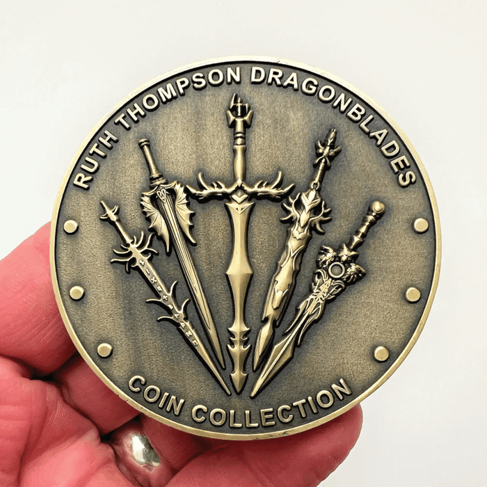 Ruth Thompson Dragonblades Coin Collection - back side of the coin held in a hand to show size, with swords upon it