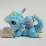 Blue dragon figurine with an open book