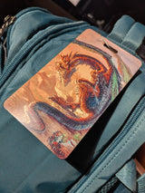 Luggage tag with a dragon and knight design on a teal suitcase