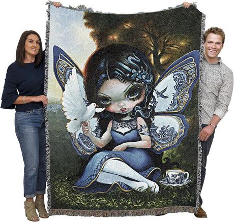 Two people holding a tapestry with a fairy design featuring a dove and a teacup.