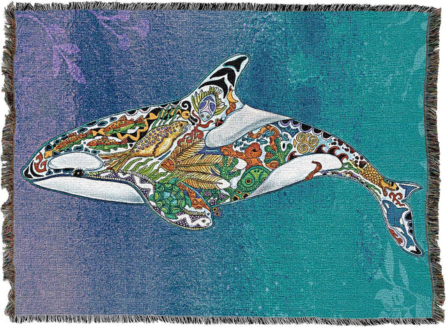 A woven throw blanket featuring a detailed, colorful patterned orca whale design on a textured blue and teal background with fringed edges.