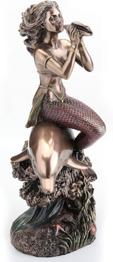 Bronze-hued mermaid on the back of a dolphin blowing into shell figurine