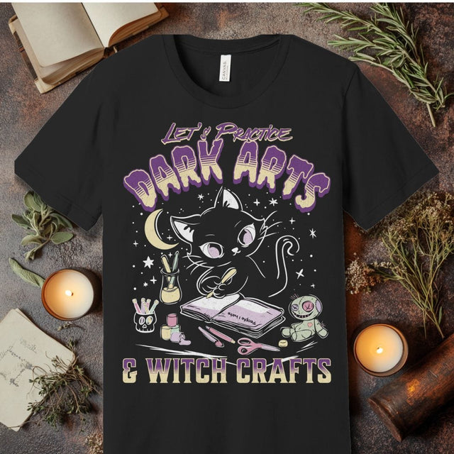 Black t-shirt with a cat graphic and text 'Let's Practice Dark Arts & Witch Crafts' on a rustic background.