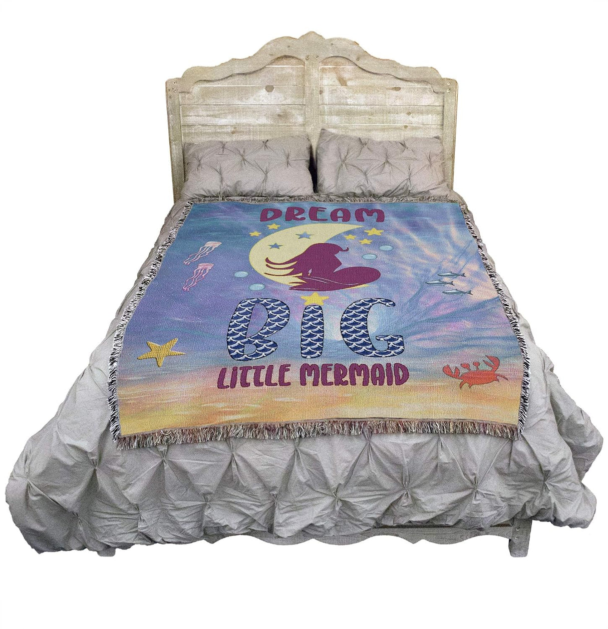 Tapestry blanket with mermaid on moon and the text "Dream Big Little Mermaid", shown on a bed