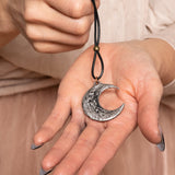 Pewter necklace - pendant is a crecsent moon, shown held