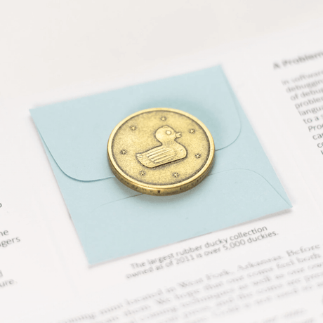 Lucky Duck coin, duck side shown in brass on packaging