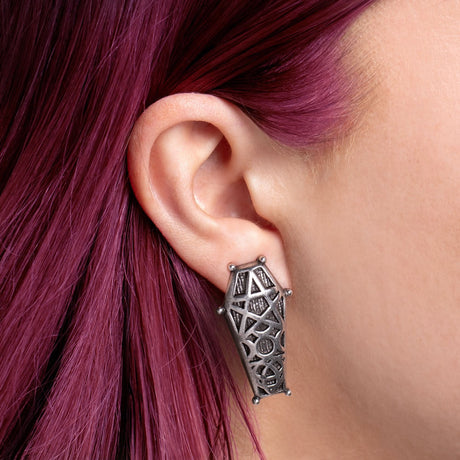 Pewter coffin earring worn by a person with pink hair
