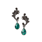 Pair of earrings with decorative metalwork and green crystals on a white background