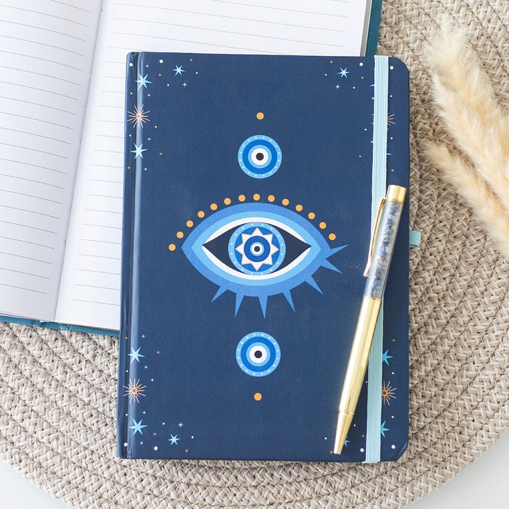 Journal with blue all seeing eye cover and gold pen with crystal chips inside