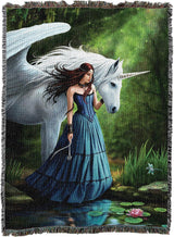 A woven tapestry featuring a fantasy illustration of a woman in a blue gown standing by a pond next to a white winged unicorn in a green forest.