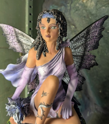 Fairy figurine with purple dress and wings, with dragon