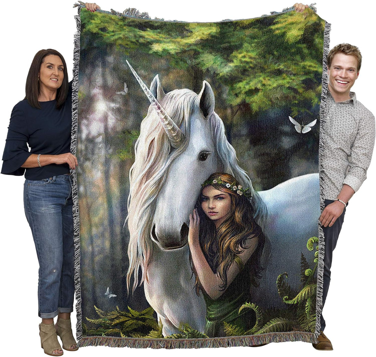 Blanket with a design of a woman hugging a unicorn in a forest setting, held by two people.