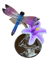 Glass dragonfly on lily