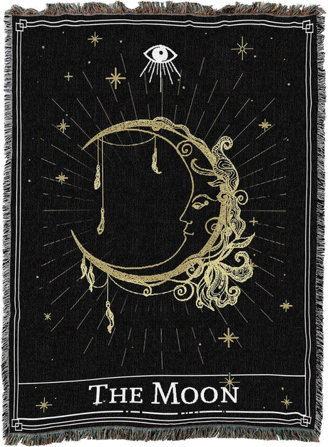 Decorative blanket with celestial design featuring 'The Moon' and eye symbol on black background