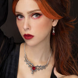Woman with red hair wearing a pewter necklace with a red heart pendant.
