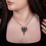 Necklace pendant with angel wings and symbol at the center with black hematite cabochon, shown worn