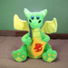 Green dragon plushie on a bed