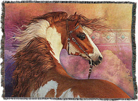 A woven throw blanket featuring a detailed tapestry-style illustration of a chestnut and white pinto horse in profile, set against a soft pink and purple background with dark fringe on all sides.