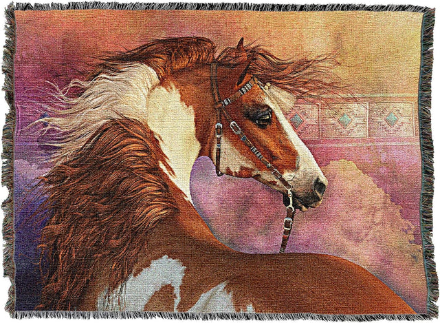 A woven throw blanket featuring a detailed tapestry-style illustration of a chestnut and white pinto horse in profile, set against a soft pink and purple background with dark fringe on all sides.