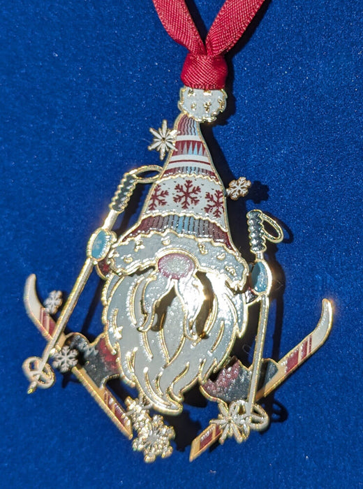Brass ornament of gnome on skis with snowflakes and a winter hat