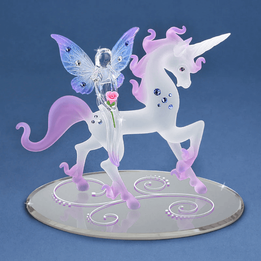Figurine of frosted glass unicorn in pink and white with jewels, and fairy sitting on it holding a rose, with blue and purple wings with more gems. Mirror base with swirls