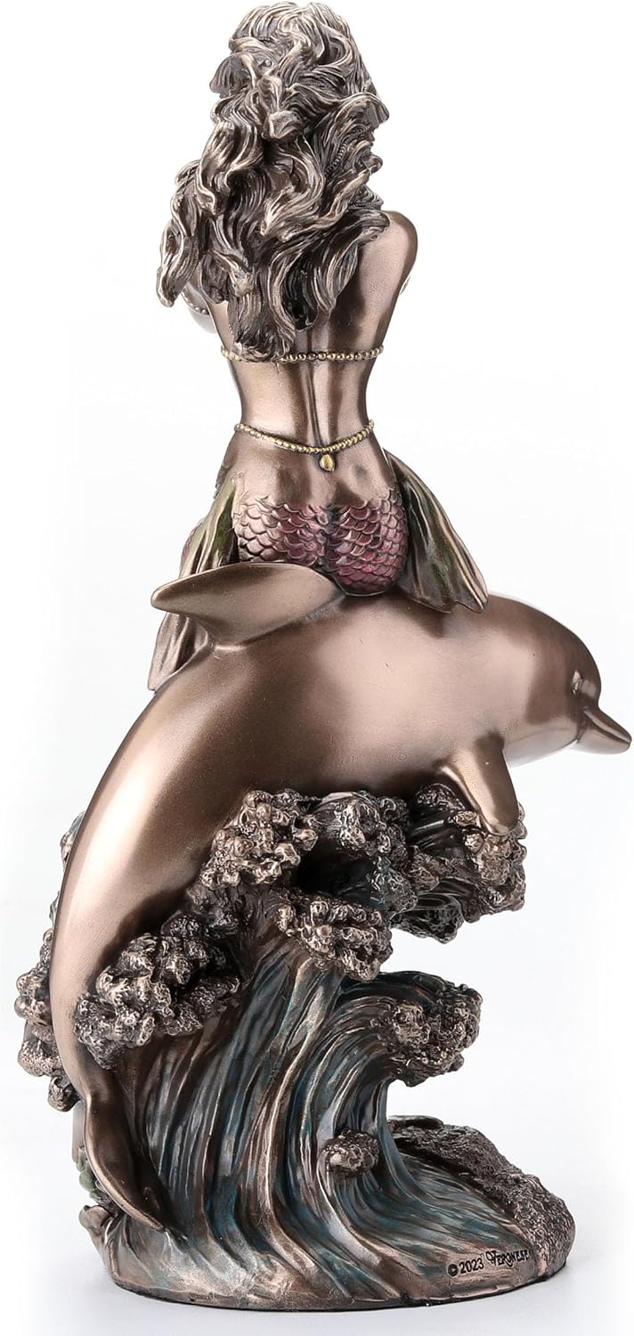 Bronze-hued mermaid on the back of a dolphin blowing into shell figurine