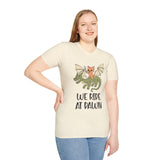Lady wearing cream t-shirt with a cat riding a dragon graphic and 'We Ride at Dawn' text