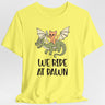 Yellow t-shirt with a cat riding a dragon graphic and 'We Ride at Dawn' text