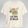 Cream t-shirt with a cat riding a dragon graphic and 'We Ride at Dawn' text