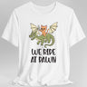 White t-shirt with a cat riding a dragon graphic and 'We Ride at Dawn' text