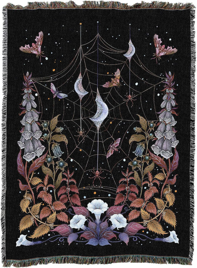 Decorative blanket with spider web, flowers, and moons design on a black background