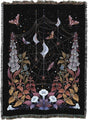Decorative blanket with spider web, flowers, and moons design on a black background