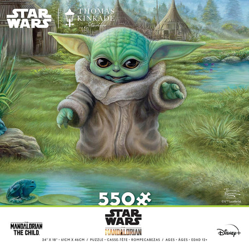 Artist Thomas Kinkade brings Grogu, affectionately known as Baby Yoda, to life in the artwork of this charming puzzle. Grogu stands at the edge of a pond, looking out at a little 'frog' on a lily pad. A wonderful gift idea for the Star Wars fan in your life! Front of 550 piece jigsaw puzzle box.