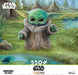Artist Thomas Kinkade brings Grogu, affectionately known as Baby Yoda, to life in the artwork of this charming puzzle. Grogu stands at the edge of a pond, looking out at a little 'frog' on a lily pad. A wonderful gift idea for the Star Wars fan in your life! Front of 550 piece jigsaw puzzle box.