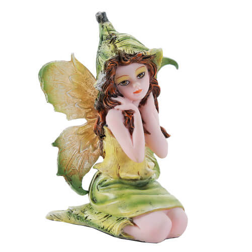 This little pixie figurine sits with her legs tucked under her, a flower bud hat on her head. She has a dress and wings of yellow and green, and rich brown hair. 