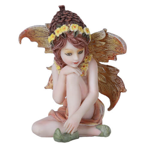 The fae figurine sits, gazing off into the distance. She wears a pinecone hat ringed with yellow flowers, and has brown and tan wings to match. 