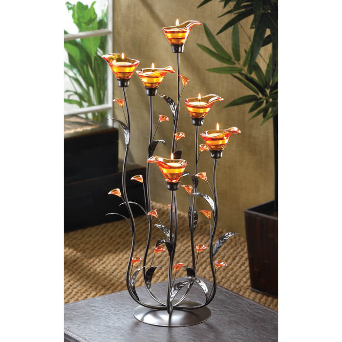 Amber calla lily candle holder, shown lit with tealights on a coffee table